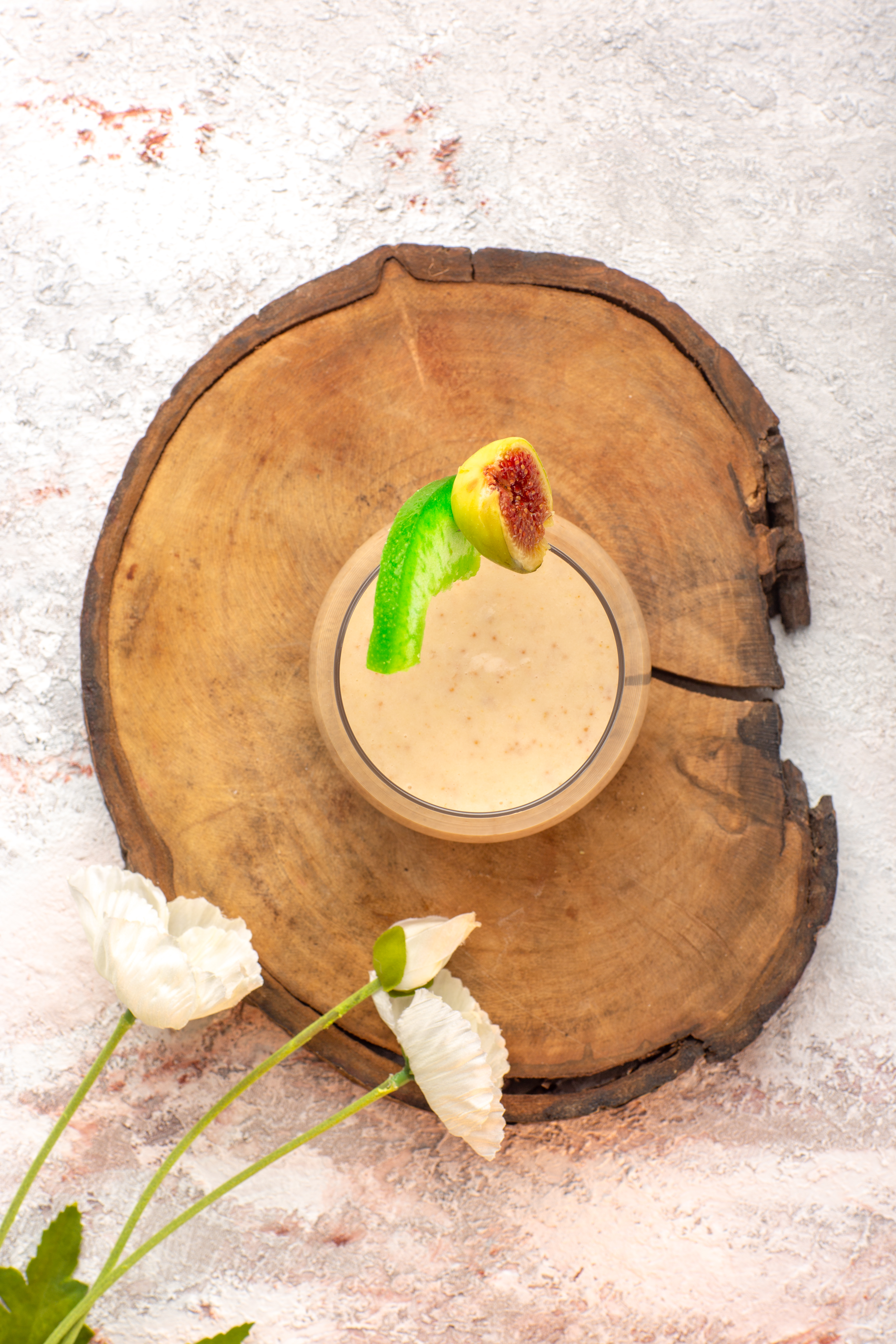top-view-creamy-cocktail-inside-little-glass-with-flowers-white-desk-cocktail-cream-color-photo-dessert